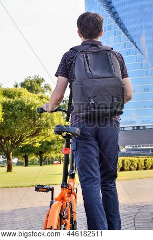 Back View Of A Young Man With Bicycle. Riding To Work By Bike, Environmentally Friendly Transport In