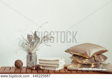 Cozy Background With Books, A Vase Of Dried Flowers And Decorative Cushes.