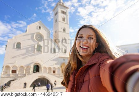 Tourist Girl In Trani Taking Selfie Photo With The Cathedral On The Background. Girl Takes Self Port