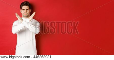 Image Of Serious And Angry Man In White Sweater, Express Storng Disapproval, Showing Cross Sign To S