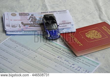Tiraspol, Moldova - April 3, 2021. A Woman's Hand Fills Out An Auto Insurance Form, Next To It Lies 