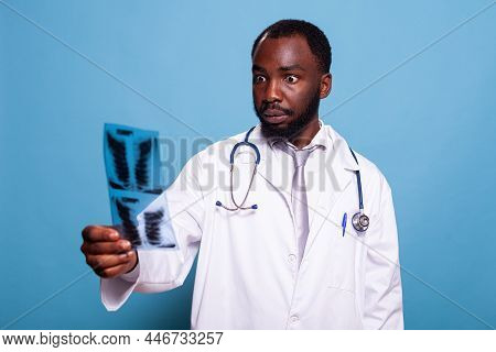 Medical Doctor In White Lab Coat With Stethoscope Looking Scared At Chest X Ray Film With Shocking T