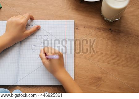Close-up Cropped Shot Of Unrecognizable Elementary Little Child Girl Drawing With Pen Doing Homework