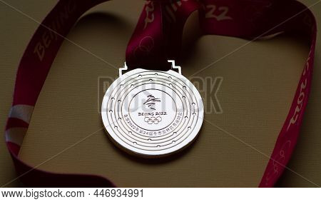 January 14, 2022, Beijing, China. Gold Medal Of The Xxiv Olympic Winter Games On A Yellow Background