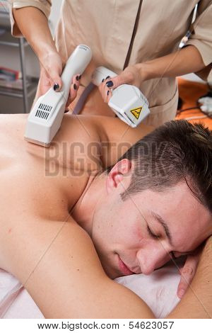 Young Man Receiving Laser Epilation On Beauty Center