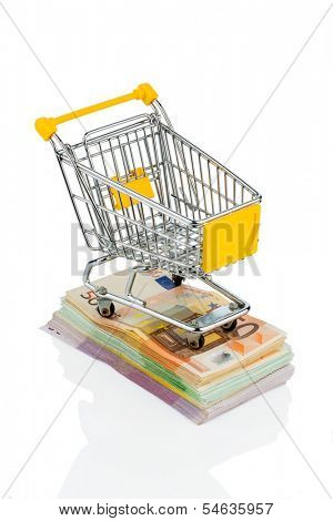 shopping cart is on banknotes, symbolic photo for shopping, purchasing power, money printing and inflation