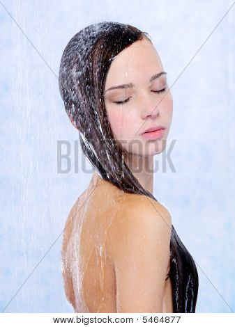 Hermosa joven relajarse tomando una ducha