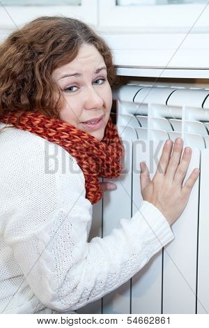 Young Woman Feels Cold Sitting Near Central Heating Convector
