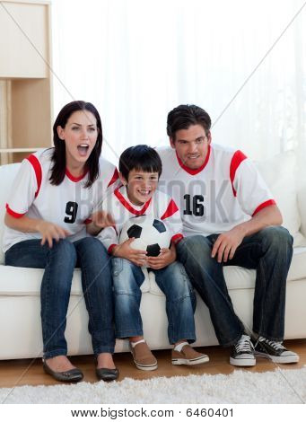 I genitori e il loro figlio guardando una partita di calcio