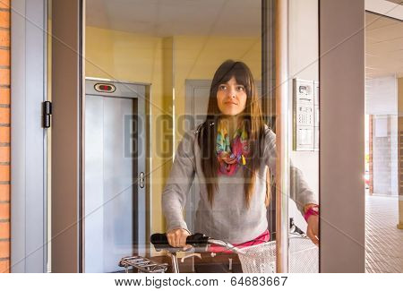 Girl with fixie bike opening a glass door to exit