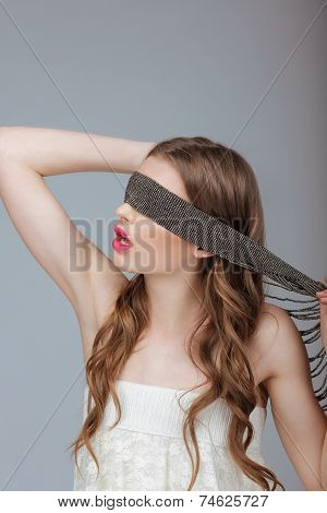 Hide And Seek. Woman Holding A Strap On Her Face. Puzzle