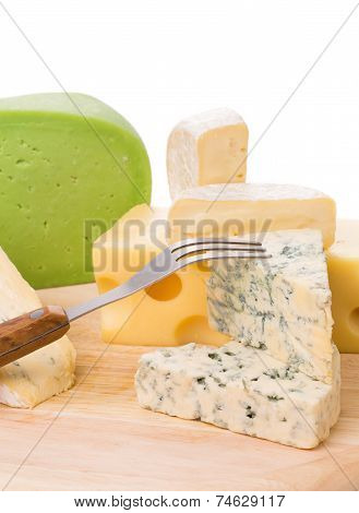 Various types of cheeses on wood.