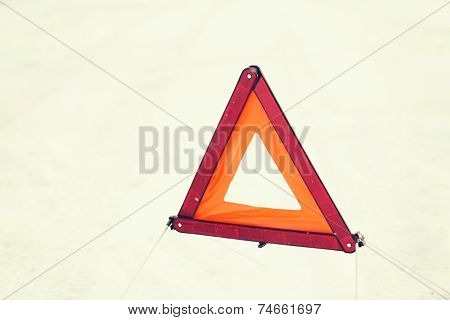 transportation and winter concept - closeup of warning triangle on snow