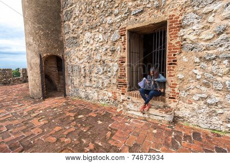 Unidentified local girl sitting in front of city fortress entrance