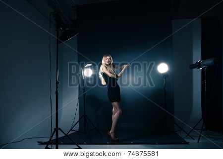 Beautiful woman posing at studio in light flashes