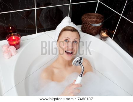 fröhlich junge Frau in einem Schaumbad singen
