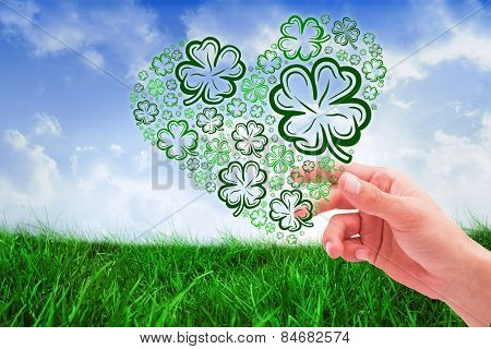 Shamrock against field of grass under blue sky