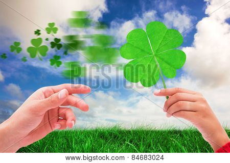 Shamrock against green grass under blue sky