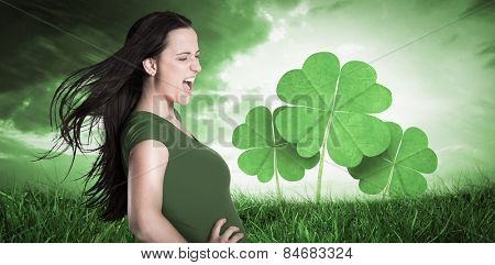 Brunette in green tshirt against orange and blue sky with clouds