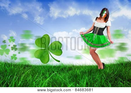 Irish girl smiling against field of grass under blue sky