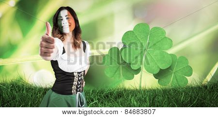 Irish girl showing thumbs up against dew on the grass close up