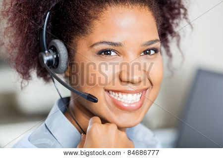 Closeup portrait of happy female customer service representative wearing headset in office