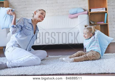 Pretty babysitter playing with little girl