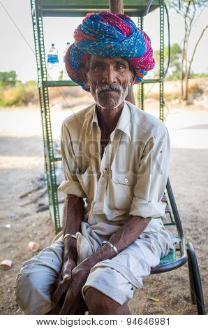 GODWAR REGION, INDIA - 13 FEBRUARY 2015: Indian tribesman sits on chair in chai shop with colorful turban on head.