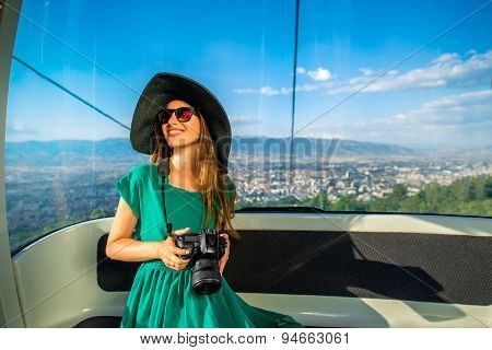 Woman in cable car with cityscape view