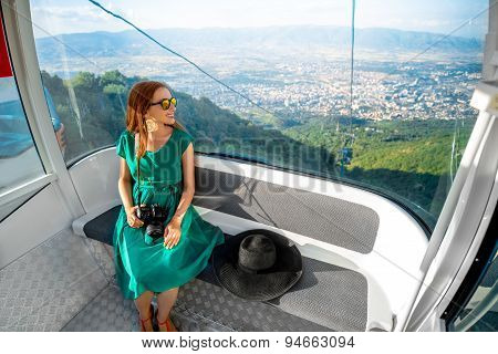 Woman in cable car with cityscape view