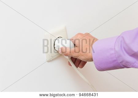 Hand Putting Plug Into Electricity Socket