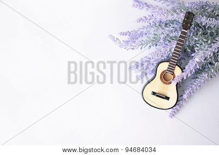 The acoustic guitar on a lavender brunch background