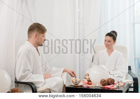 Photo of attractive man and woman relaxing in spa salon
