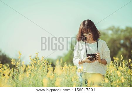 Young woman with camera in the Sunhemp garden vintage tone