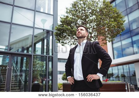 Businessman standing with hands on hips in office premises