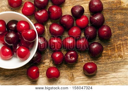 photographed close-up of ripe red cherries covered with water drops, shallow depth of field, photo taken from above. Berries on the table