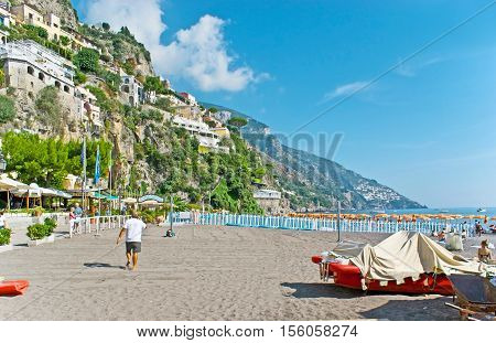 POSITANO ITALY - OCTOBER 5 2012: The walk along Marina Grande lying at the foot of the steep rock with villas and hotels cafes and restaurants of the picturesque resort on October 5 in Positano.