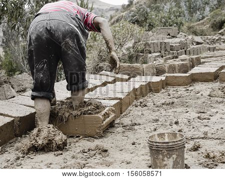 Boy Making Traditional Adobe Mud Bricks In Paru Paru Community Village, Pisaq District, Cusco Region