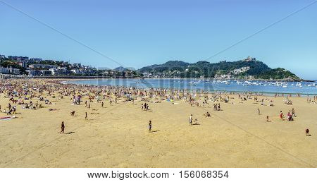 San Sebastian Spain - August 22 2016: Watches on the beach promenade of La Concha in San Sebastian in a sunny day on August