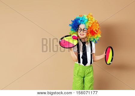 Blithesome Children. Portrait Of Happy Clown Boy Wearing Large Neon Coloured Wig