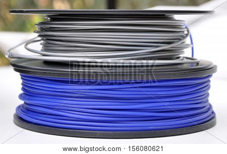 two 3d printing filament spools, silver and blue