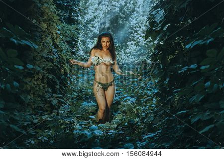slim woman in underwear leaf looking at the camera outdoors in the forest