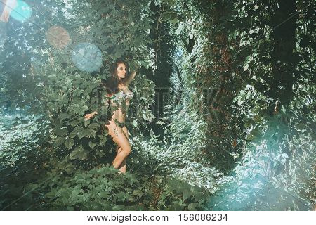 outdoors portrait of sensual young woman in underwear leaf in the sunny forest