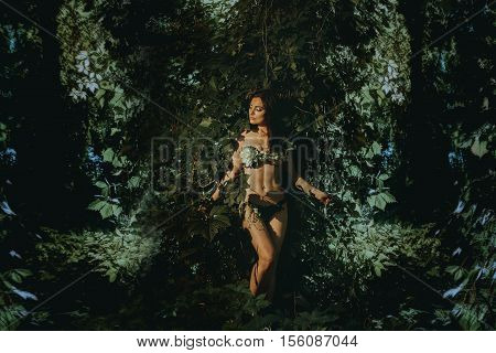 lovely slim young woman in the forest posing in underwear leaf