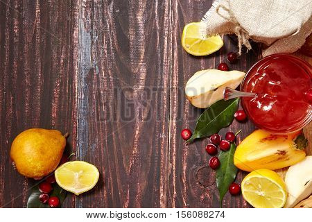 Berry and fruit jam with ingredients on a dark rustic background. Copy space top view.