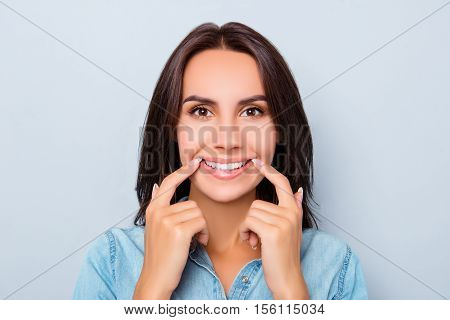 Pretty Woman Making Fake Smile With Her Fingers Stretching The Corners Of Her Mouth