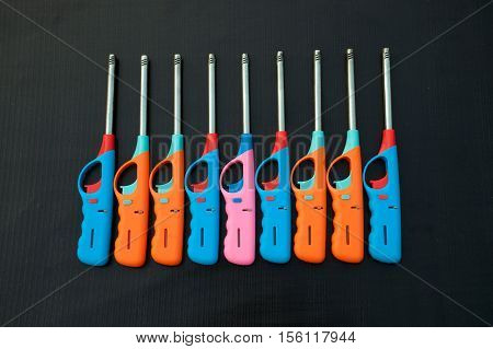 Group of colorful Gas lighter gun for gas-stove on a black background.