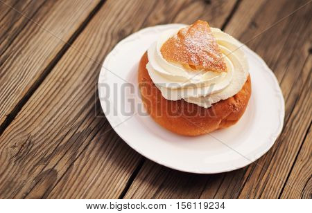 A delicious semla with whipped cream on a plate