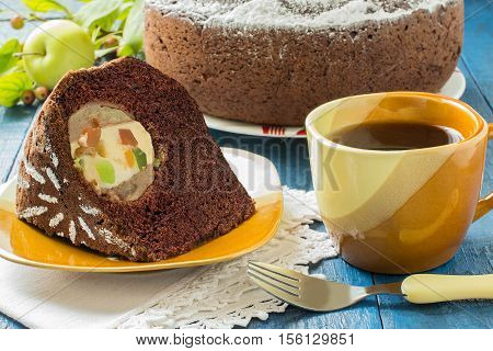 Baking in multicooker. Delicious homemade chocolate cake with whole apples curd and candied fruit on a blue wooden table. Selective focus