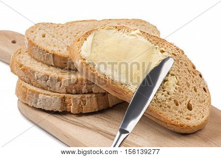 Close up a knife spreading butter on bread